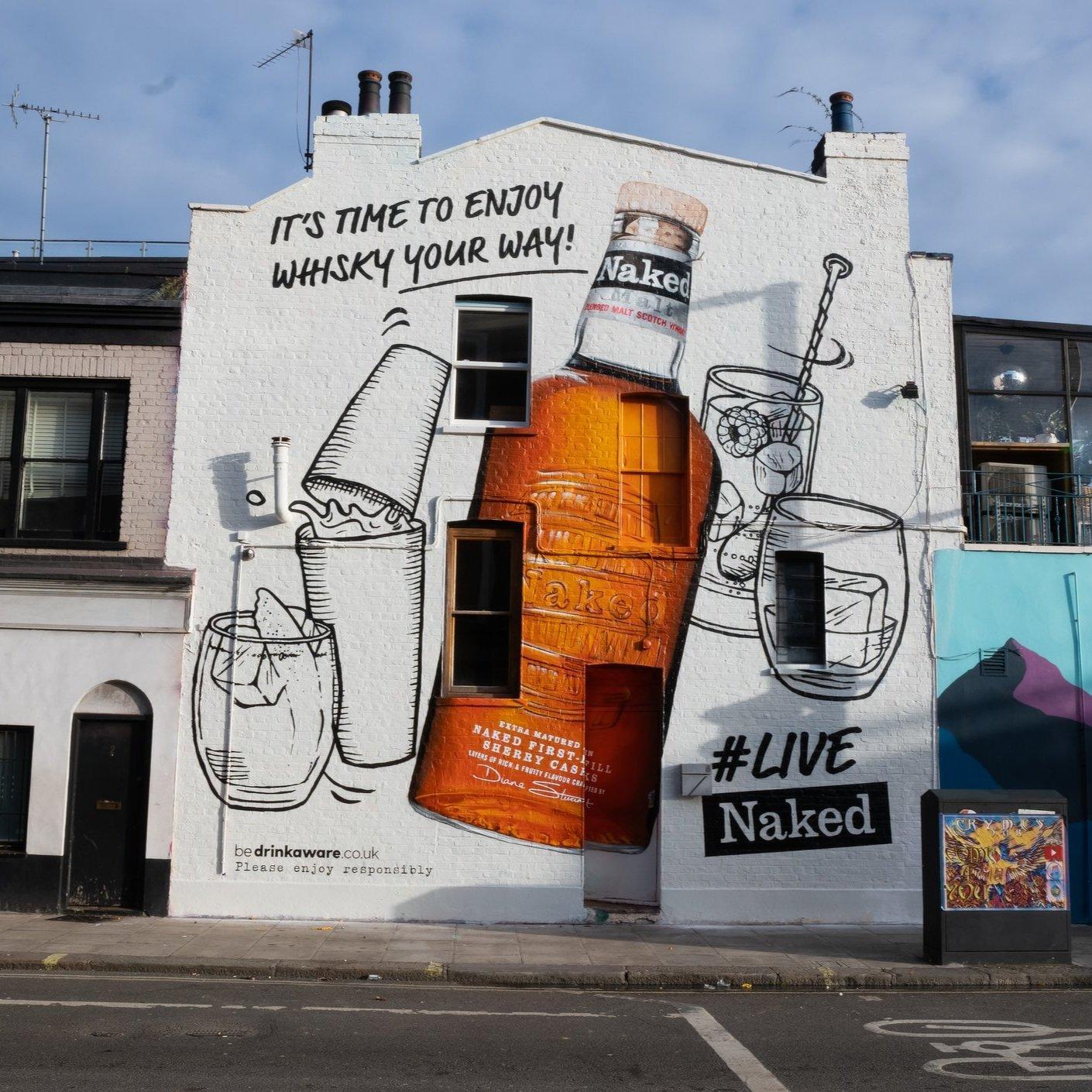 A building with a Naked Whisky Ad painted on the side.