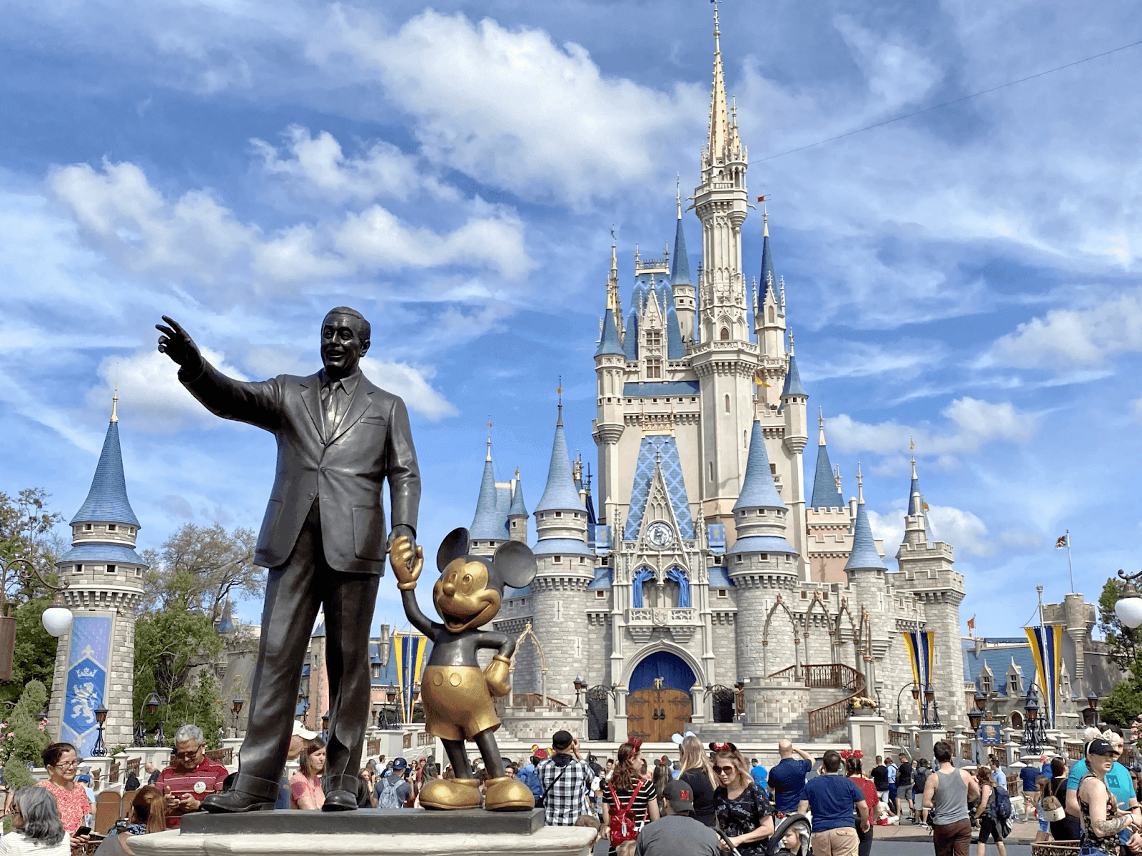 Walt disney & Mickey Mouse statue in front of the Disney castle
