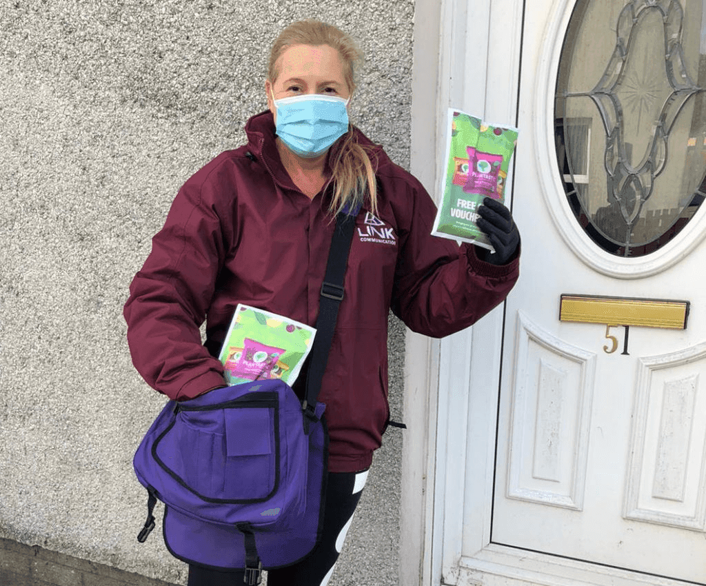 Woman outside her home holding up something she just won