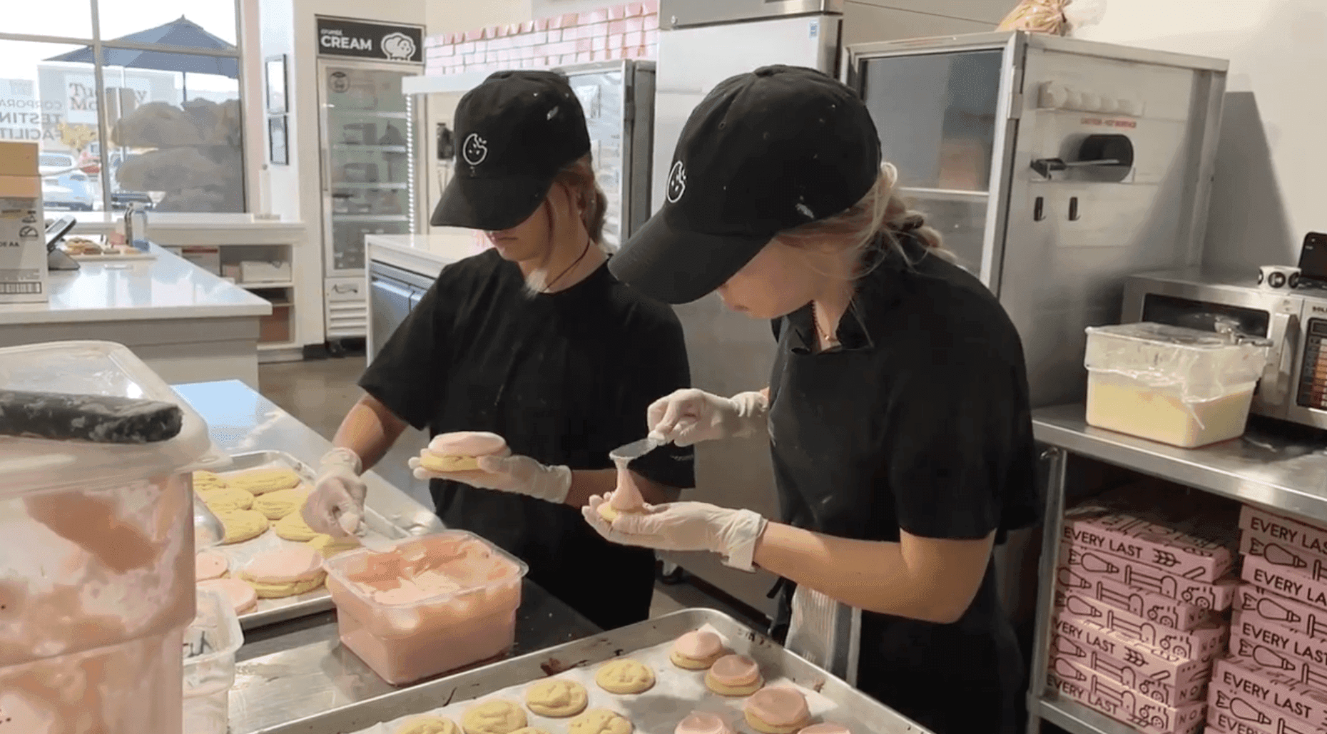 Two female workers preparing food behind the counter at the store