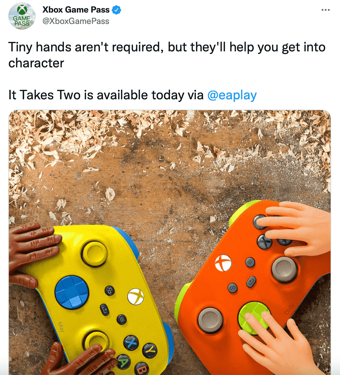 Xbox Game Pass tweet about "It Takes Two" available on EA Play with picture of tiny hands playing with Xbox controllers